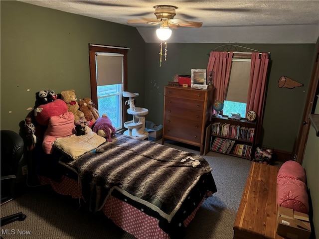 bedroom with ceiling fan, carpet floors, vaulted ceiling, and a textured ceiling