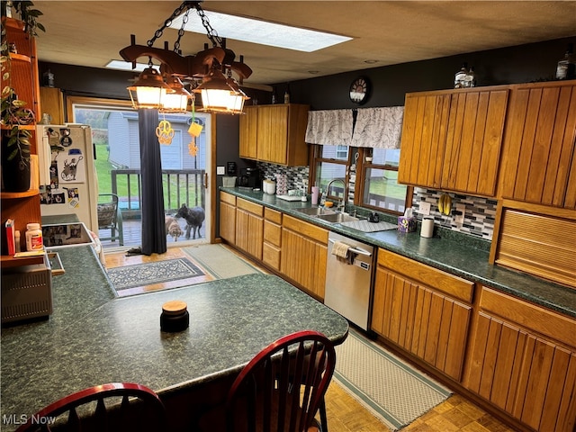 kitchen with a skylight, dishwasher, plenty of natural light, and tasteful backsplash