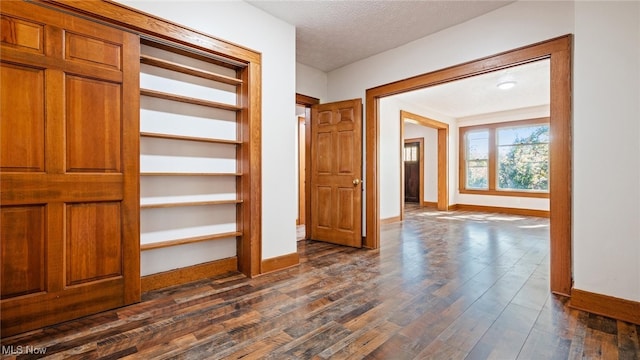 hall featuring dark hardwood / wood-style floors and a textured ceiling