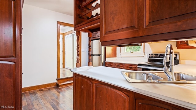 kitchen with dark wood-type flooring, appliances with stainless steel finishes, and sink