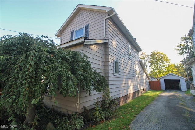 view of property exterior with a garage and an outbuilding