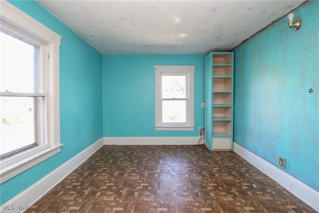 spare room with dark parquet floors