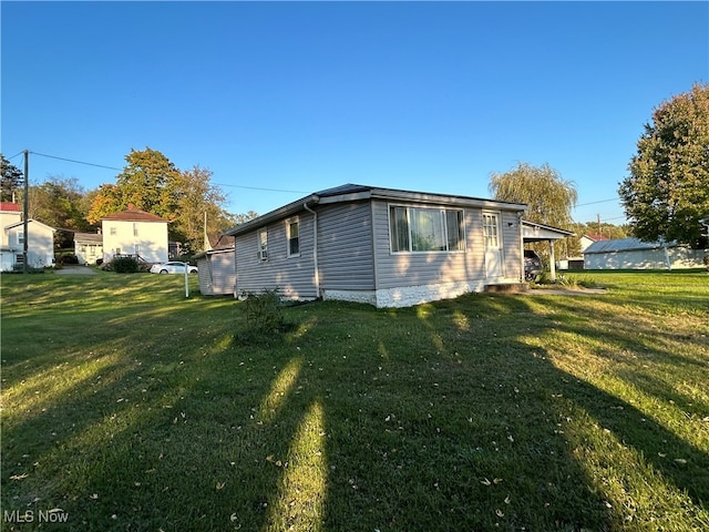 view of side of home with a yard