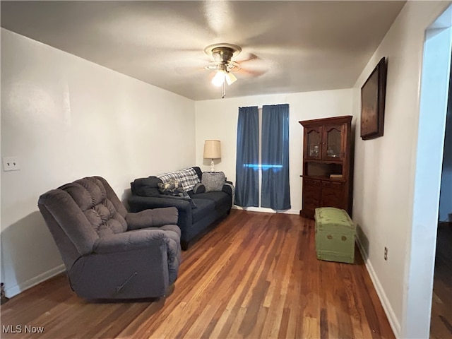 living room featuring dark hardwood / wood-style flooring and ceiling fan