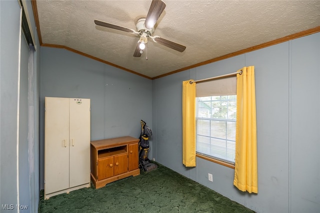 empty room featuring carpet floors, ceiling fan, vaulted ceiling, ornamental molding, and a textured ceiling