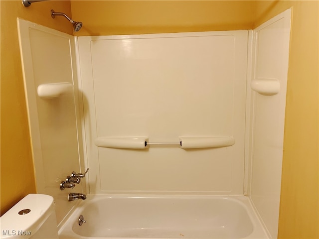 bathroom featuring shower / washtub combination and toilet