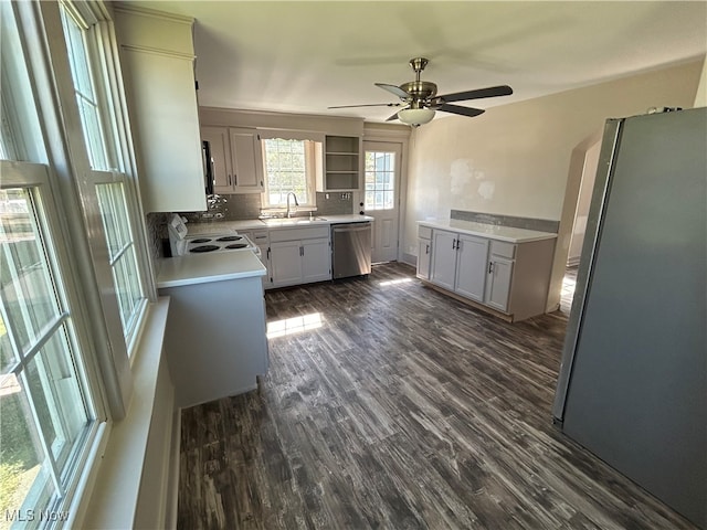 kitchen featuring sink, backsplash, ceiling fan, stainless steel appliances, and dark hardwood / wood-style floors