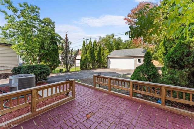 view of patio / terrace featuring a garage, an outbuilding, and central AC unit