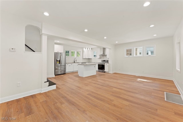 unfurnished living room featuring light hardwood / wood-style floors and sink