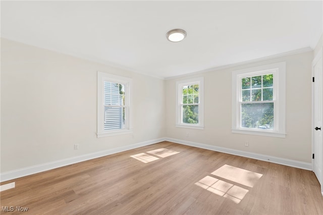 unfurnished room featuring ornamental molding and light wood-type flooring