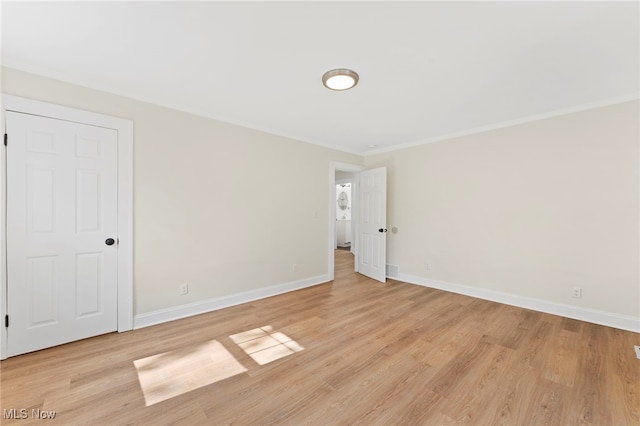 spare room with light wood-type flooring and crown molding