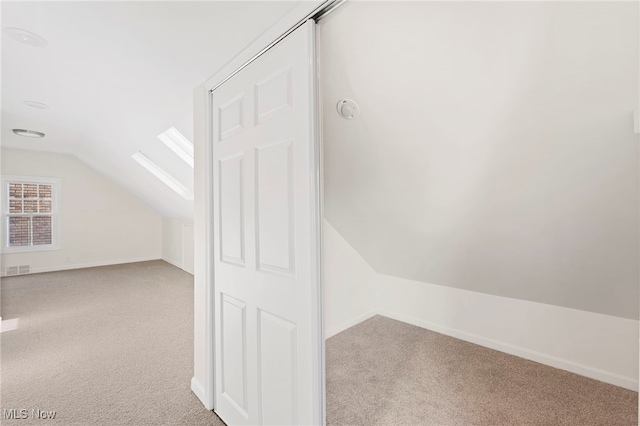 bonus room featuring light colored carpet and lofted ceiling with skylight