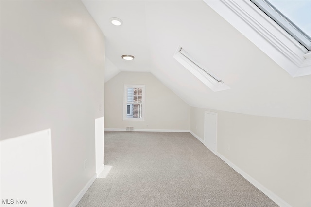 bonus room featuring lofted ceiling with skylight and light carpet