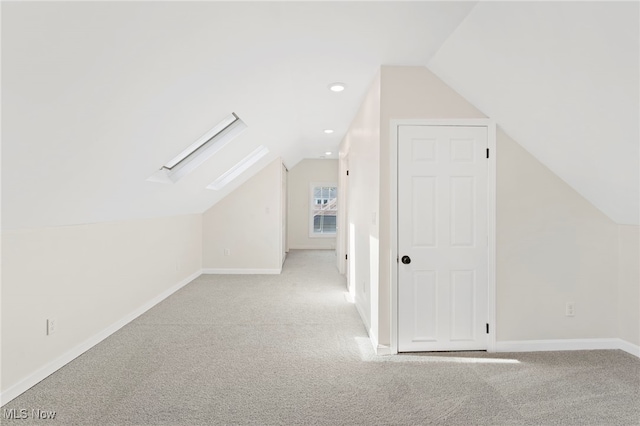 additional living space with light carpet and vaulted ceiling with skylight