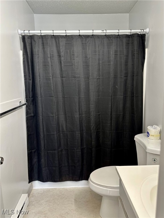 bathroom featuring a shower with curtain, vanity, toilet, and a textured ceiling