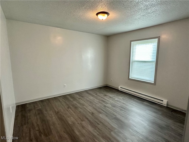 spare room featuring a baseboard heating unit, dark hardwood / wood-style floors, and a textured ceiling