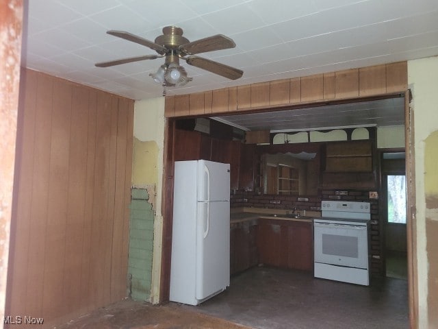 kitchen featuring wood walls, white appliances, sink, and ceiling fan