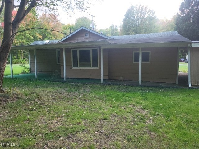 rear view of property with a yard