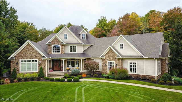 craftsman-style house featuring covered porch and a front lawn