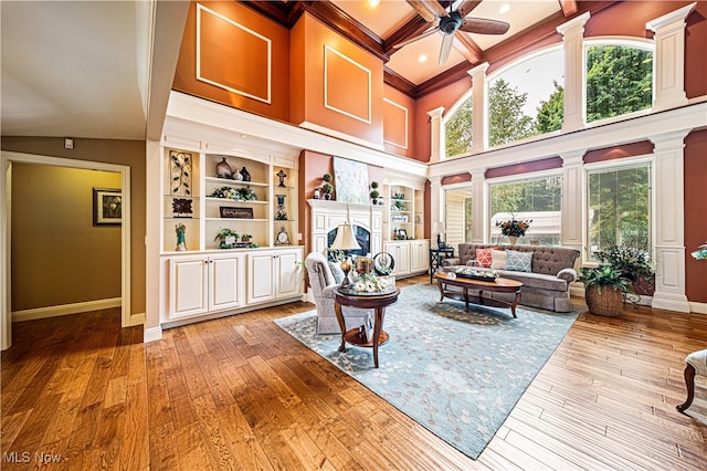 living room featuring a wealth of natural light, ceiling fan, beam ceiling, and light hardwood / wood-style floors