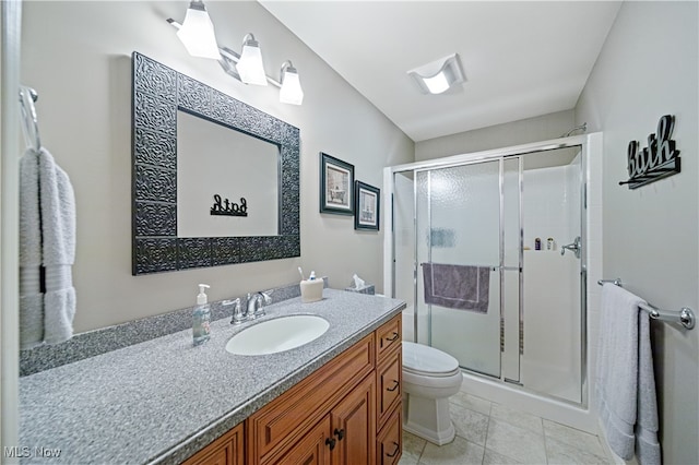 bathroom with tile patterned flooring, vanity, toilet, and an enclosed shower