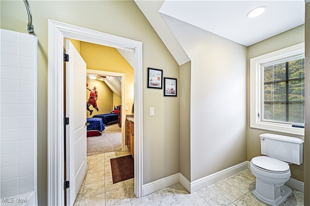 bathroom with tile patterned floors, toilet, and vaulted ceiling