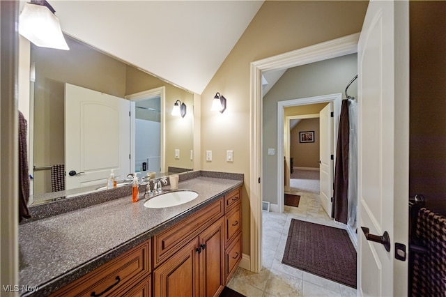 bathroom with vanity, lofted ceiling, and tile patterned floors