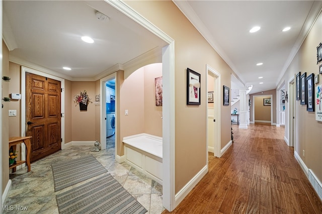 corridor featuring ornamental molding, light hardwood / wood-style flooring, and washer / dryer