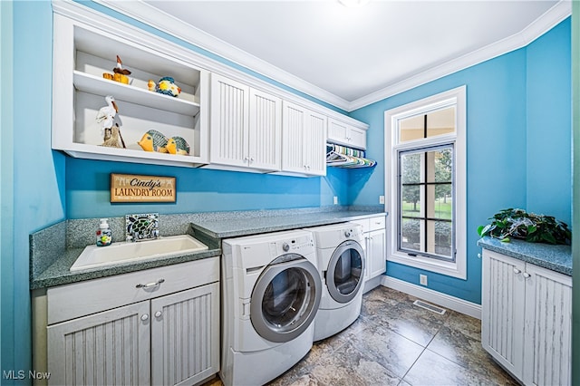 laundry area with ornamental molding, cabinets, sink, and independent washer and dryer