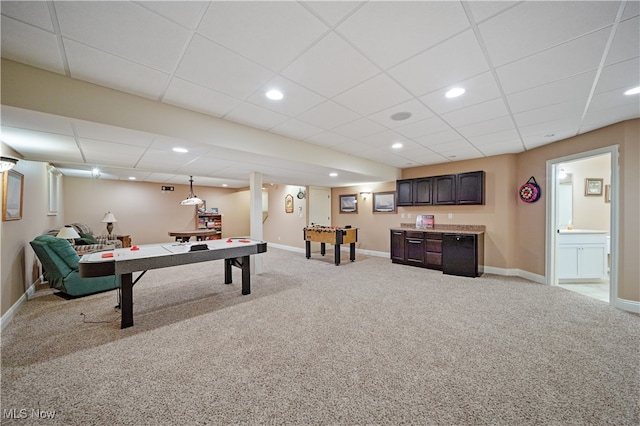 recreation room featuring a paneled ceiling and light carpet