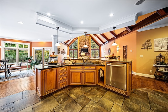 kitchen with vaulted ceiling with skylight, decorative light fixtures, sink, dark wood-type flooring, and stainless steel dishwasher