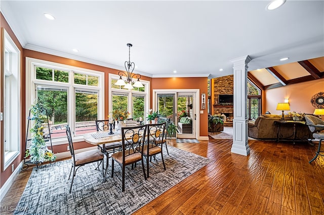 dining room featuring wood-type flooring, a notable chandelier, decorative columns, ornamental molding, and lofted ceiling with beams