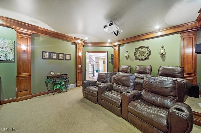 carpeted home theater featuring decorative columns and crown molding