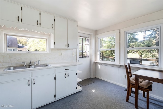 kitchen with backsplash, sink, and white cabinetry