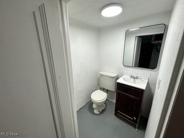 bathroom featuring tile patterned flooring, vanity, and toilet