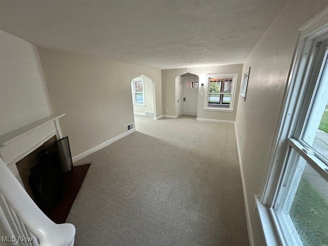 unfurnished living room with a textured ceiling and carpet flooring