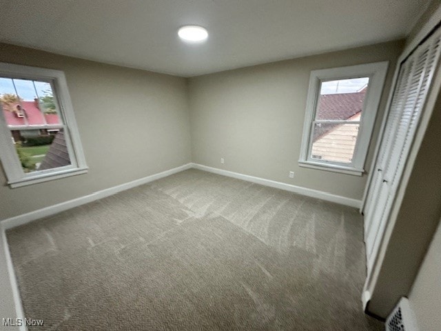 unfurnished bedroom featuring a closet, carpet, and multiple windows