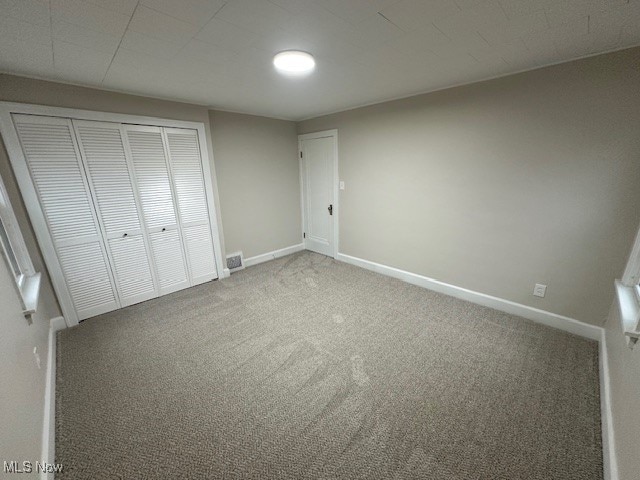 unfurnished bedroom with carpet floors and a closet