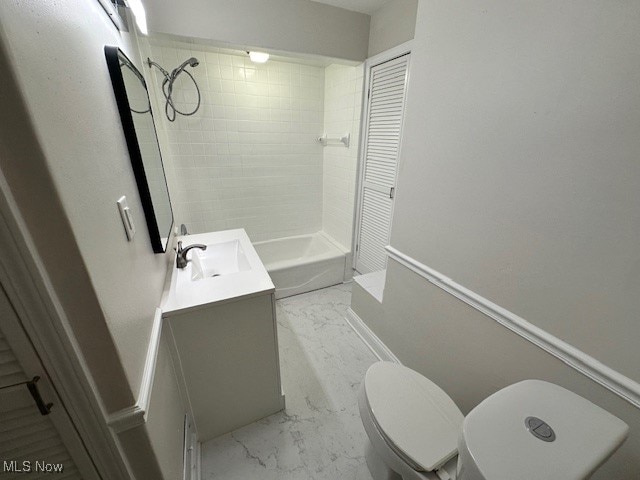 bathroom featuring toilet, tiled shower, and vanity