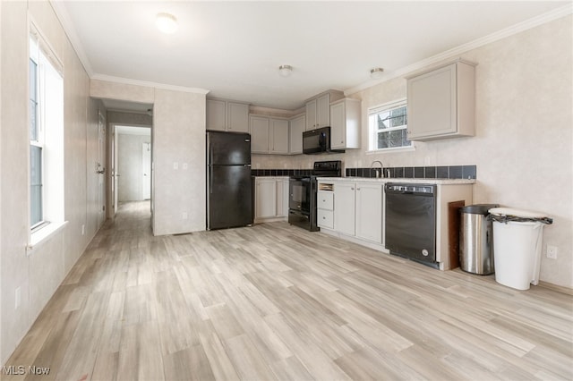 kitchen with gray cabinets, light hardwood / wood-style flooring, black appliances, and ornamental molding