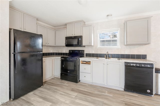 kitchen featuring black appliances, sink, crown molding, and light hardwood / wood-style flooring