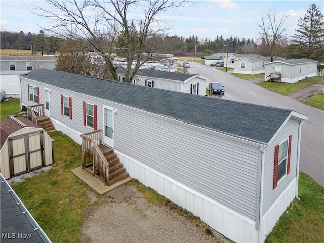 view of front of property featuring a storage shed