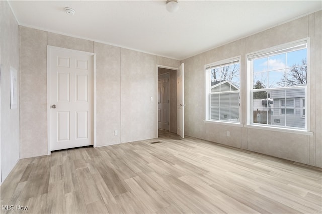 unfurnished bedroom with light wood-type flooring and a closet