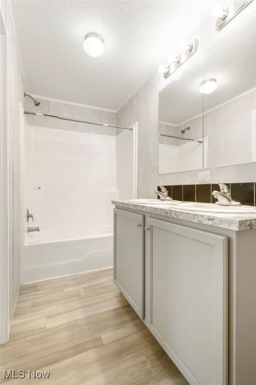 bathroom featuring a textured ceiling, vanity, hardwood / wood-style flooring, and shower / bathtub combination