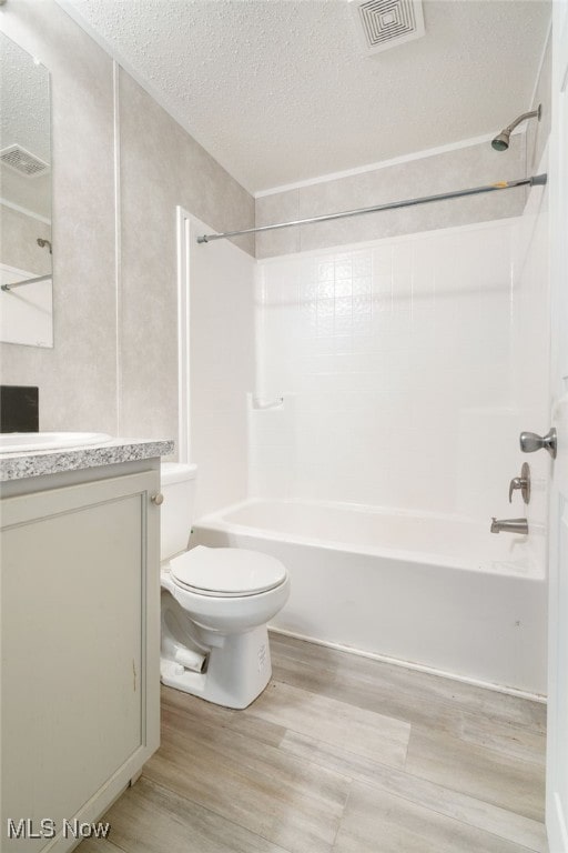 full bathroom featuring vanity, toilet, a textured ceiling, and bathing tub / shower combination