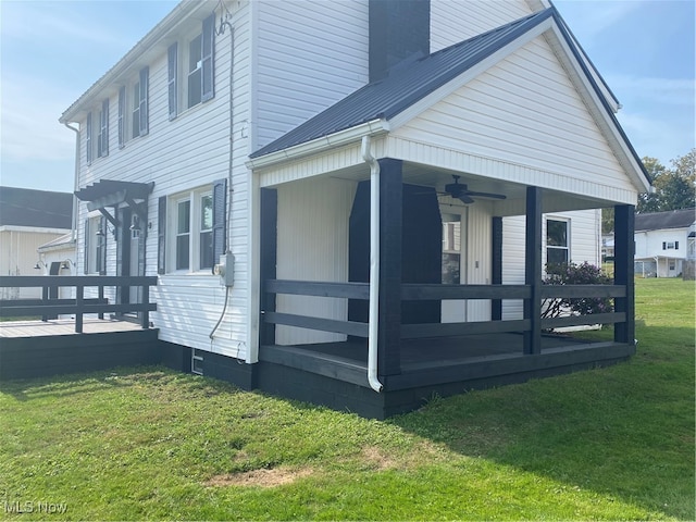 view of home's exterior featuring ceiling fan and a yard