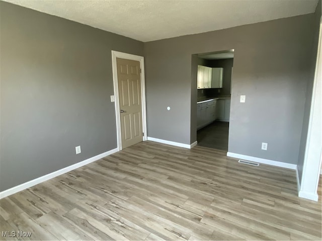 interior space featuring light hardwood / wood-style floors and a textured ceiling