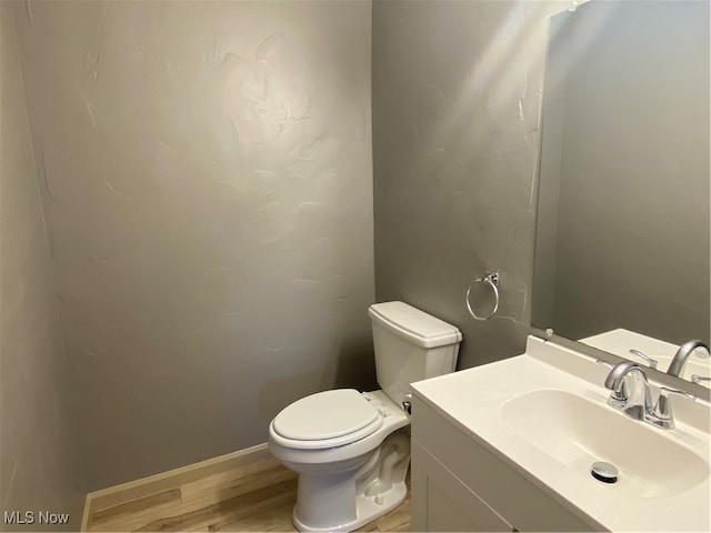 bathroom featuring hardwood / wood-style floors, vanity, and toilet