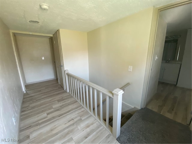 stairs featuring hardwood / wood-style flooring and a textured ceiling