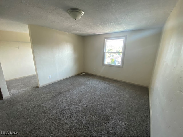 carpeted spare room with a textured ceiling